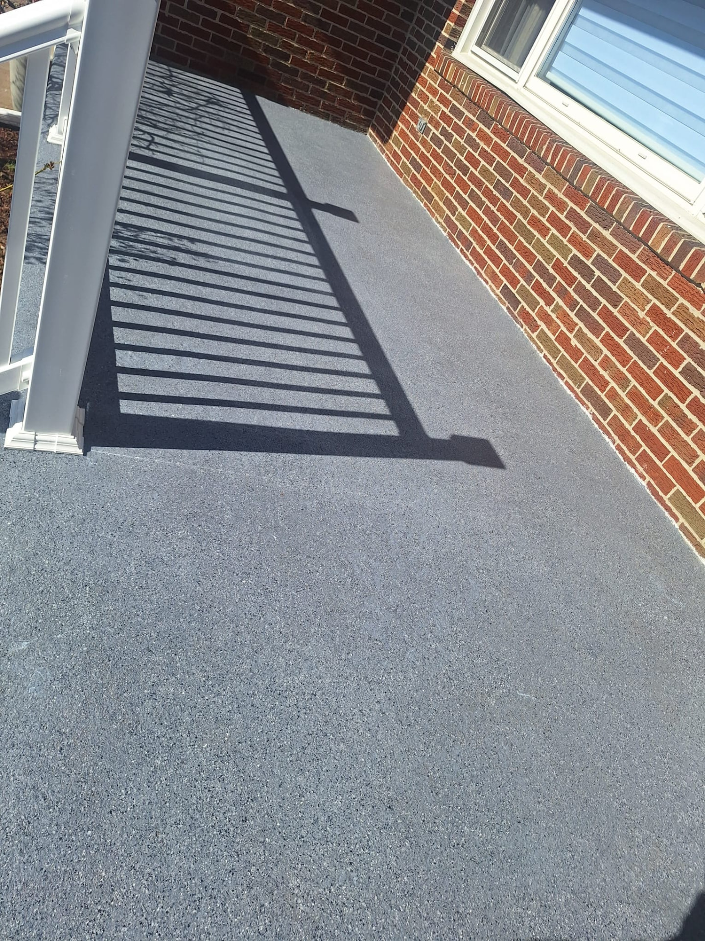 Grani-Flex coated walkway alongside a brick home